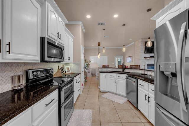 312 Fox Xing, Burnet, TX 78611 - kitchen with appliances with stainless steel finishes, a sink, a peninsula, decorative backsplash, and light tile patterned floors
