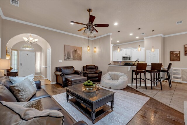 312 Fox Xing, Burnet, TX 78611 - living area with arched walkways, ceiling fan, ornamental molding, light wood finished floors, and recessed lighting