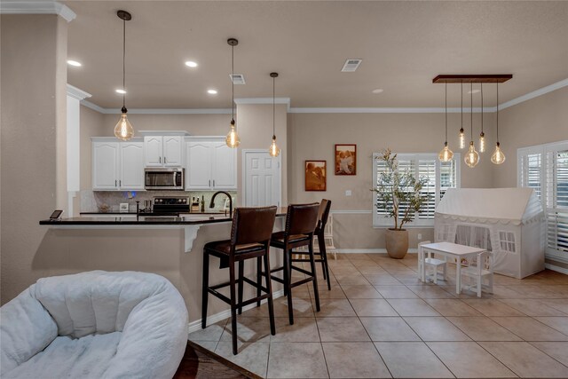 312 Fox Xing, Burnet, TX 78611 - kitchen featuring appliances with stainless steel finishes, ornamental molding, tasteful backsplash, dark countertops, and white cabinetry