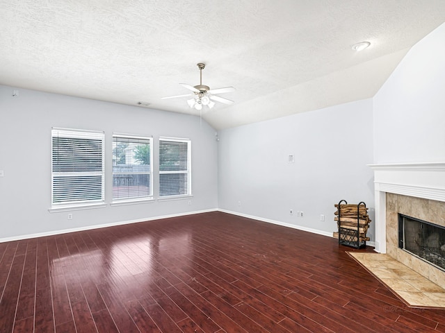 25203 Auburn Terrace Dr, Spring, TX 77389 - unfurnished living room with ceiling fan, baseboards, a tiled fireplace, wood finished floors, and a textured ceiling