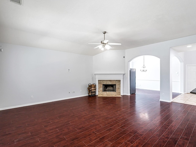 25203 Auburn Terrace Dr, Spring, TX 77389 - unfurnished living room with ceiling fan, wood finished floors, a tile fireplace, baseboards, and arched walkways