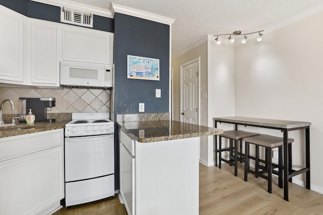 6102 Seawall Blvd Unit 260, Galveston, TX 77551 - kitchen with white appliances, crown molding, a sink, a peninsula, and white cabinets