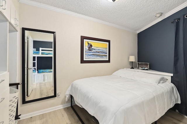 6102 Seawall Blvd Unit 260, Galveston, TX 77551 - bedroom featuring wood finished floors, crown molding, a textured ceiling, and baseboards