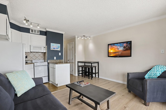 6102 Seawall Blvd Unit 260, Galveston, TX 77551 - living area with crown molding, a textured ceiling, light wood-style flooring, rail lighting, and baseboards