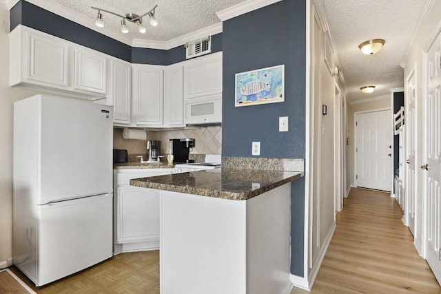 6102 Seawall Blvd Unit 260, Galveston, TX 77551 - kitchen featuring white appliances, a textured ceiling, white cabinetry, backsplash, and a peninsula