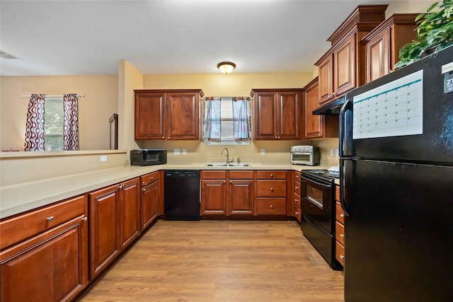 2709 Virginia St, La Marque, TX 77568 - kitchen with black appliances, a sink, plenty of natural light, and under cabinet range hood
