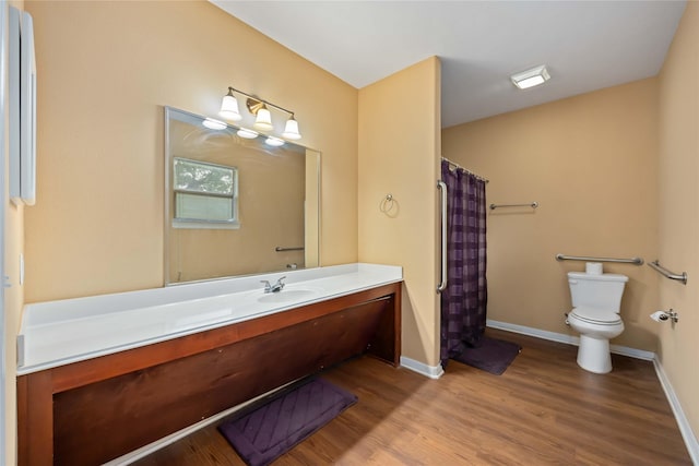 2709 Virginia St, La Marque, TX 77568 - bathroom with toilet, wood finished floors, vanity, curtained shower, and baseboards