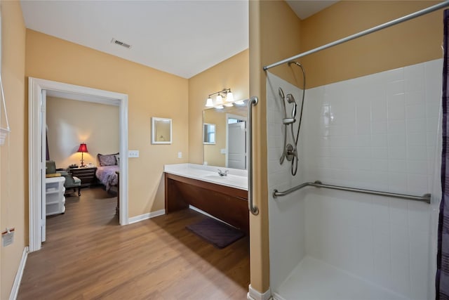 2709 Virginia St, La Marque, TX 77568 - bathroom featuring a shower, wood finished floors, vanity, and baseboards