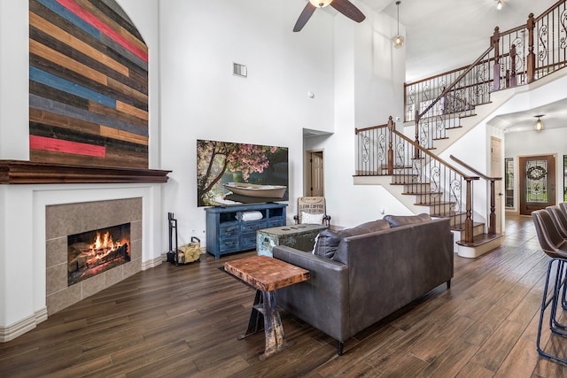 6907 Autumn Rain Ln, Spring, TX 77379 - living room with a high ceiling, wood finished floors, a tile fireplace, stairway, and a ceiling fan
