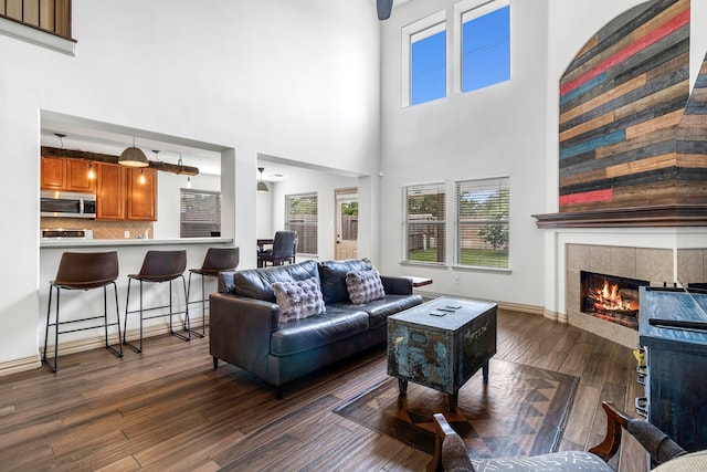 6907 Autumn Rain Ln, Spring, TX 77379 - living area with a fireplace, dark wood-style flooring, and a high ceiling