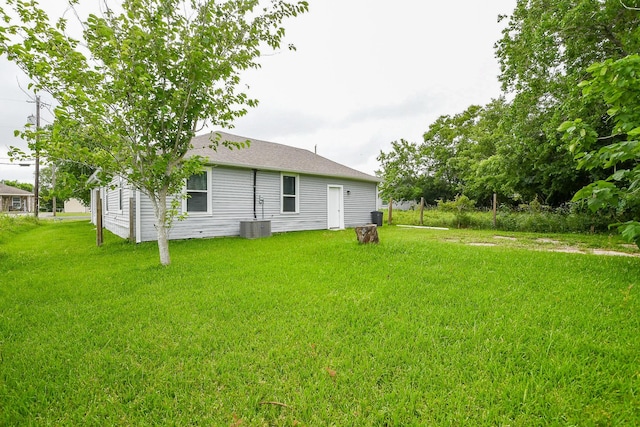 312 Hemphill St, Texas City, TX 77591 - rear view of property featuring a lawn, central air condition unit, and roof with shingles