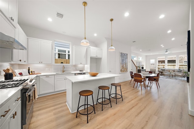 5238 Larkin St, Houston, TX 77007 - kitchen featuring gas range, a sink, tasteful backsplash, light wood-style floors, and a kitchen island