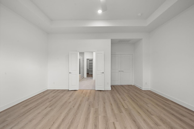5238 Larkin St, Houston, TX 77007 - unfurnished bedroom featuring light wood-style flooring, baseboards, a raised ceiling, and a closet