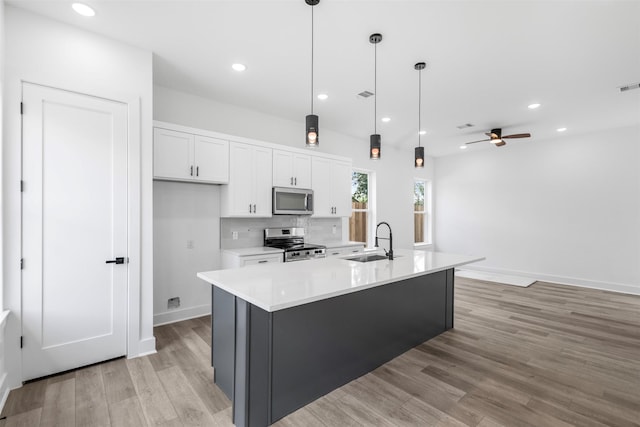2475 Carmel St A/B, Unit A/B Houston, TX 77091 - kitchen with stainless steel appliances, a sink, white cabinets, light wood-type flooring, and light countertops