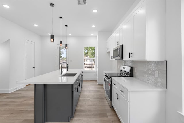 2475 Carmel St A/B, Unit A/B Houston, TX 77091 - kitchen with stainless steel appliances, a sink, baseboards, white cabinets, and recessed lighting