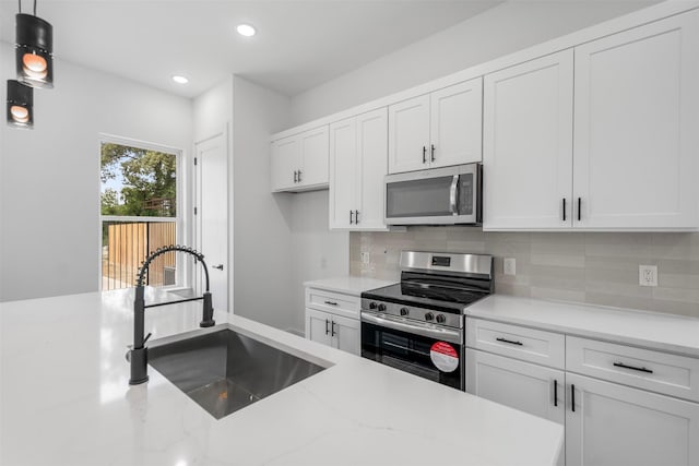 2475 Carmel St A/B, Unit A/B Houston, TX 77091 - kitchen featuring appliances with stainless steel finishes, a sink, backsplash, white cabinets, and recessed lighting