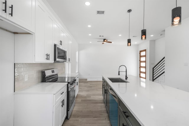 2475 Carmel St A/B, Unit A/B Houston, TX 77091 - kitchen featuring appliances with stainless steel finishes, a sink, recessed lighting, light wood-style flooring, and white cabinets