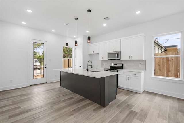 2475 Carmel St A/B, Unit A/B Houston, TX 77091 - kitchen featuring appliances with stainless steel finishes, a sink, white cabinetry, light wood-style floors, and recessed lighting