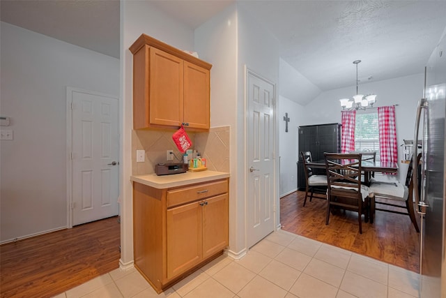 18019 Iris Edge Way, Cypress, TX 77429 - kitchen with a chandelier, light wood-style flooring, light countertops, tasteful backsplash, and vaulted ceiling