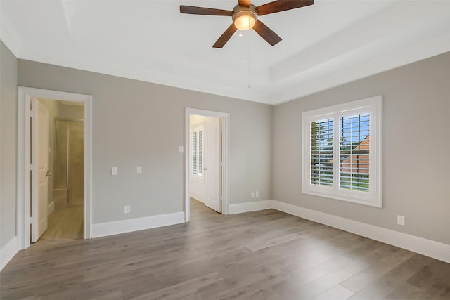 1518 Hillendahl Blvd, Houston, TX 77055 - unfurnished bedroom with wood finished floors, a raised ceiling, ensuite bath, and ceiling fan