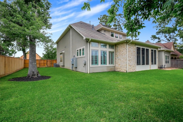 1518 Hillendahl Blvd, Houston, TX 77055 - back of house with a fenced backyard, stone siding, stucco siding, and a shingled roof