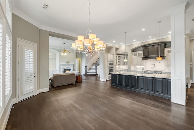 1518 Hillendahl Blvd, Houston, TX 77055 - kitchen with a chandelier, dark wood-type flooring, a lit fireplace, ornamental molding, and decorative backsplash
