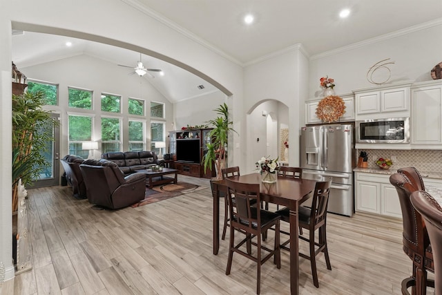 18786 Monetta Dr, New Caney, TX 77357 - dining area with arched walkways, ceiling fan, high vaulted ceiling, light wood finished floors, and recessed lighting