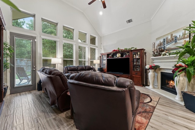 18786 Monetta Dr, New Caney, TX 77357 - living room with ceiling fan, ornamental molding, a lit fireplace, wood finished floors, and high vaulted ceiling