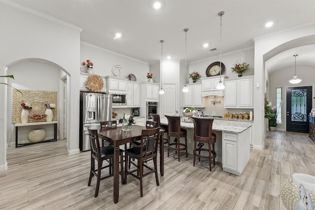 18786 Monetta Dr, New Caney, TX 77357 - dining room featuring recessed lighting, light wood finished floors, arched walkways, and ornamental molding
