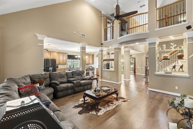 3602 Blue Lake Dr, Spring, TX 77388 - living area with decorative columns, ceiling fan, wood finished floors, a high ceiling, and baseboards