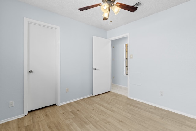 11818 Guadalupe River Dr, Houston, TX 77067 - spare room featuring light wood-style flooring, a ceiling fan, a textured ceiling, and baseboards