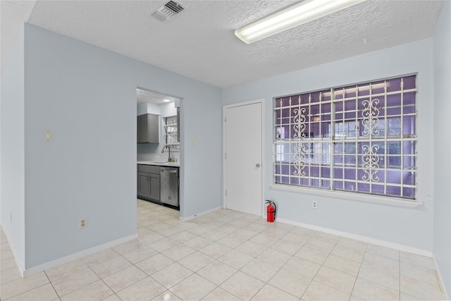 11818 Guadalupe River Dr, Houston, TX 77067 - unfurnished room featuring a sink, a textured ceiling, baseboards, and light tile patterned floors