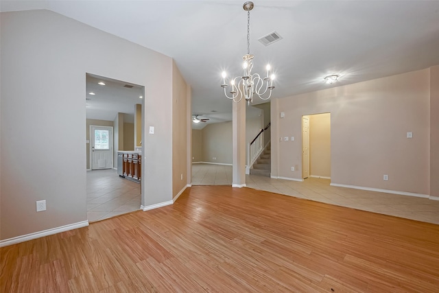 16715 Red Falls Cir, Houston, TX 77095 - empty room with light wood-style flooring, stairs, a chandelier, a ceiling fan, and baseboards