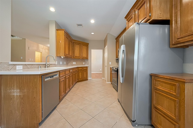 16715 Red Falls Cir, Houston, TX 77095 - kitchen with stainless steel appliances, a sink, light tile patterned floors, brown cabinets, and recessed lighting