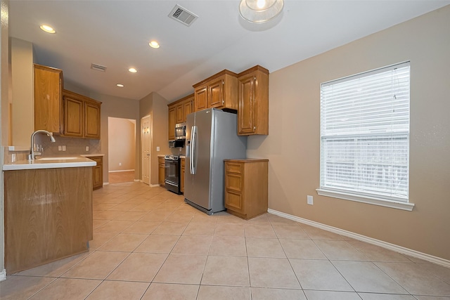 16715 Red Falls Cir, Houston, TX 77095 - kitchen with stainless steel appliances, a sink, light tile patterned floors, tasteful backsplash, and baseboards