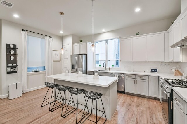 2818 Grand Fountains Dr Unit C, Houston, TX 77054 - kitchen with appliances with stainless steel finishes, a sink, light wood finished floors, a breakfast bar area, and recessed lighting