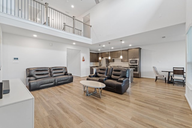 5411 Cavall Rd, Missouri City, TX 77459 - living area featuring a towering ceiling, light wood finished floors, recessed lighting, and baseboards