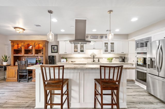 15726 Steamboat Ln, Houston, TX 77079 - kitchen featuring appliances with stainless steel finishes, a sink, light wood-style floors, island range hood, and recessed lighting