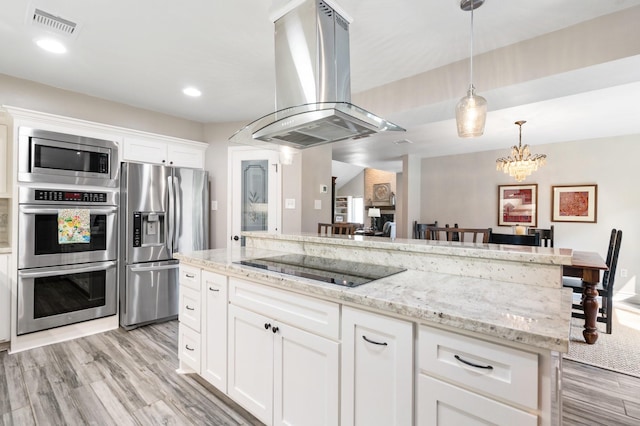 15726 Steamboat Ln, Houston, TX 77079 - kitchen featuring appliances with stainless steel finishes, island exhaust hood, light wood-type flooring, light stone countertops, and white cabinets