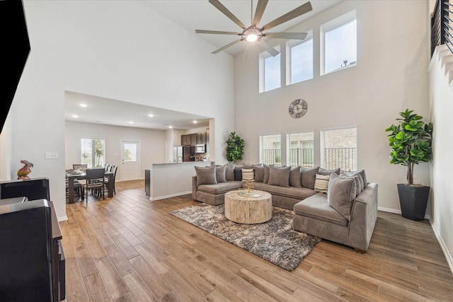 1523 Alpine Dr, Rosharon, TX 77583 - living area featuring ceiling fan, a high ceiling, light wood-type flooring, and baseboards