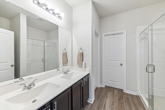 1523 Alpine Dr, Rosharon, TX 77583 - bathroom featuring wood finished floors, a shower stall, baseboards, and double vanity