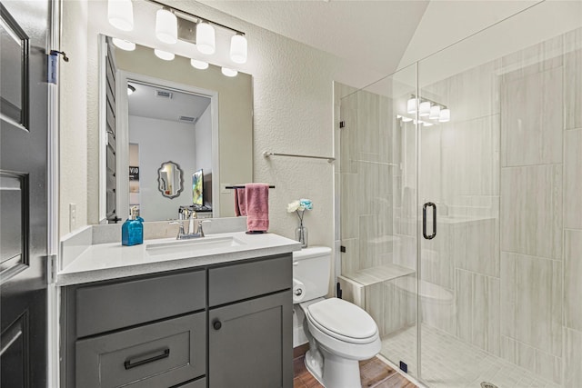 21511 Blue Porterweed Trl, Cypress, TX 77433 - bathroom featuring a textured wall, toilet, a shower stall, vanity, and wood finished floors