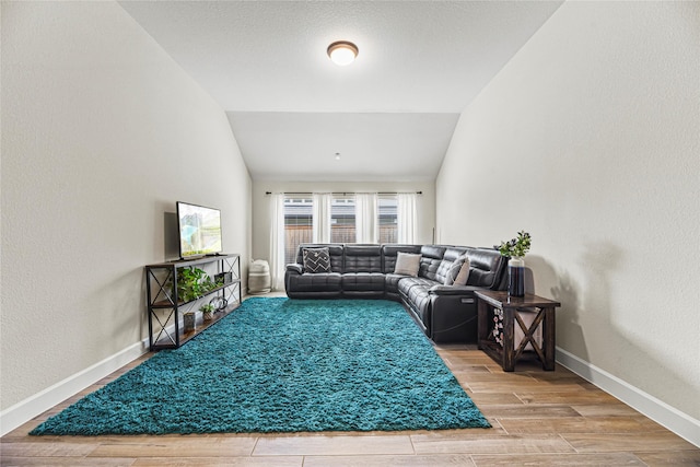 21511 Blue Porterweed Trl, Cypress, TX 77433 - living room featuring vaulted ceiling, baseboards, wood finished floors, and a textured wall