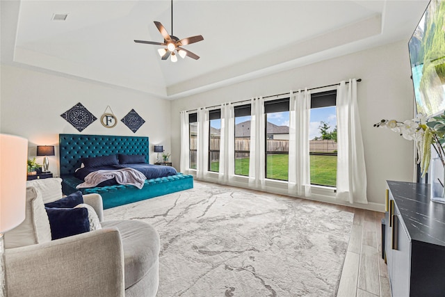 21511 Blue Porterweed Trl, Cypress, TX 77433 - bedroom with light wood-style flooring, a ceiling fan, high vaulted ceiling, and a raised ceiling