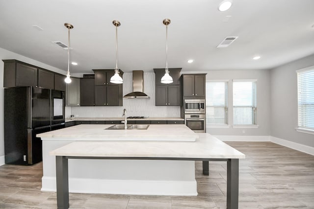 30702 Barred Owl Way, Brookshire, TX 77423 - kitchen featuring stainless steel appliances, wall chimney range hood, a sink, baseboards, and tasteful backsplash
