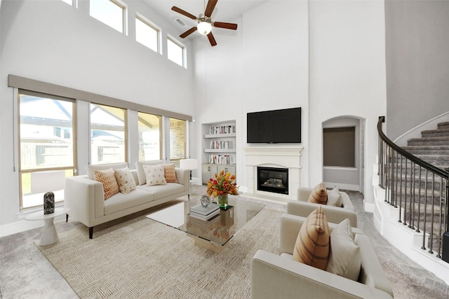 30702 Barred Owl Way, Brookshire, TX 77423 - living area featuring a high ceiling, a ceiling fan, a glass covered fireplace, carpet flooring, and stairway