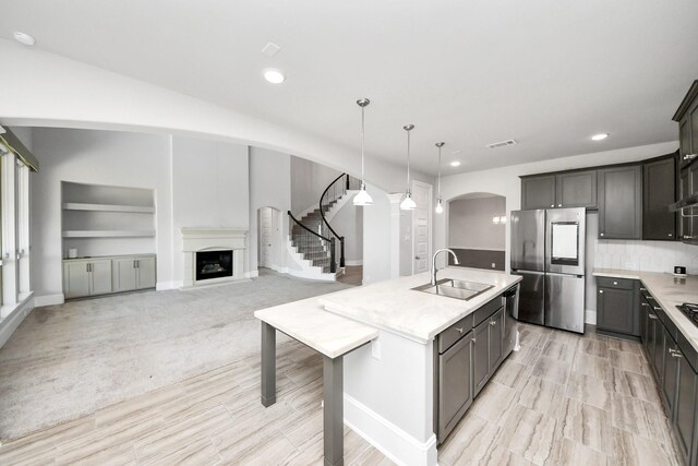30702 Barred Owl Way, Brookshire, TX 77423 - kitchen featuring a sink, appliances with stainless steel finishes, arched walkways, light countertops, and recessed lighting