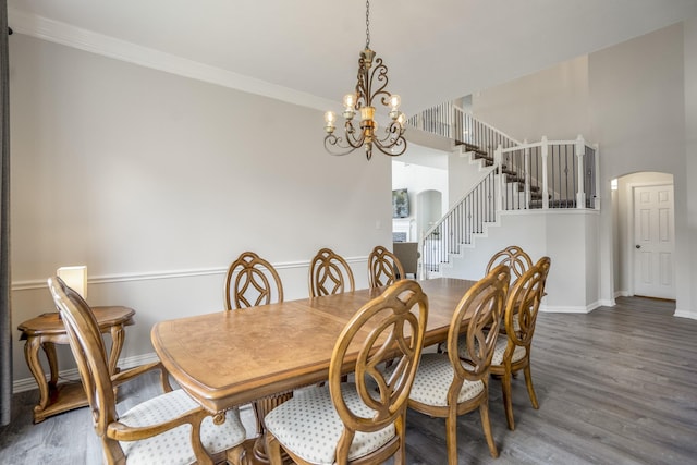 10522 Kirkwell Manor Ct, Spring, TX 77379 - dining room featuring arched walkways, stairs, a chandelier, wood finished floors, and baseboards