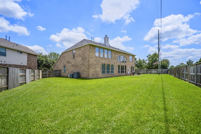 10522 Kirkwell Manor Ct, Spring, TX 77379 - rear view of house with a chimney, brick siding, and central AC