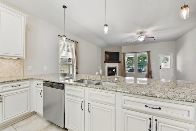 22907 Caverly Ln, Tomball, TX 77375 - kitchen with dishwasher, a sink, a ceiling fan, backsplash, and a fireplace